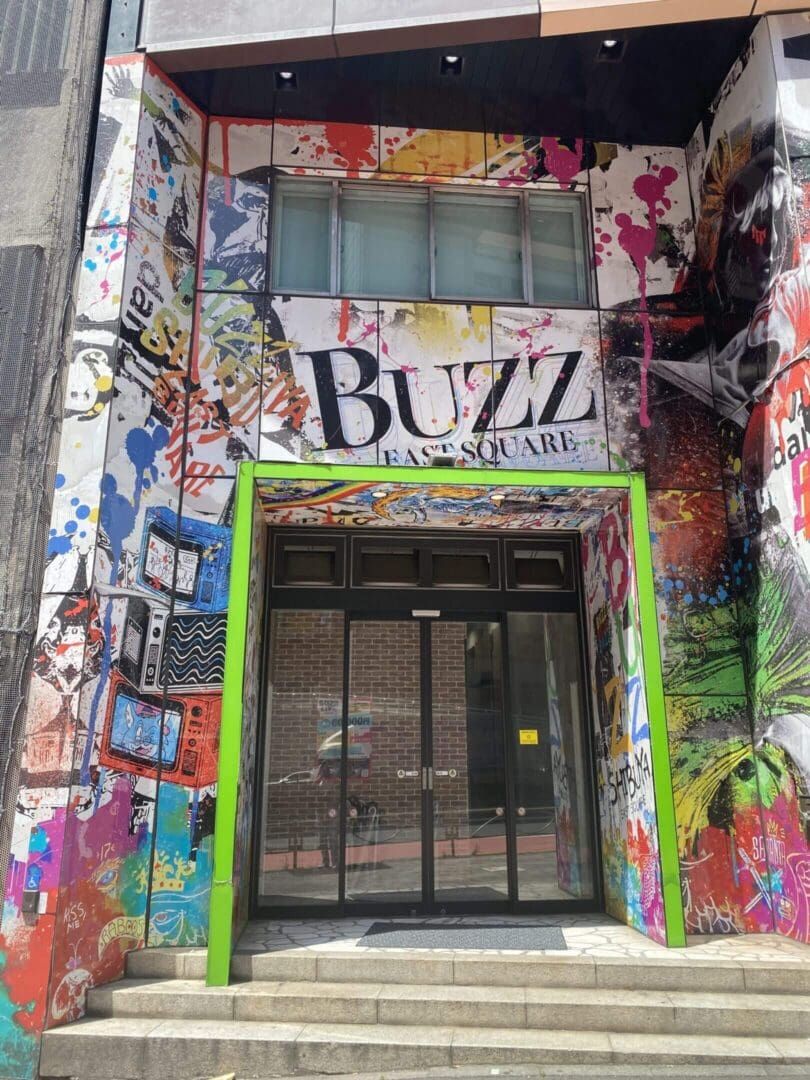 Colorful graffiti surrounds the entrance of Buzz Art Gallery.