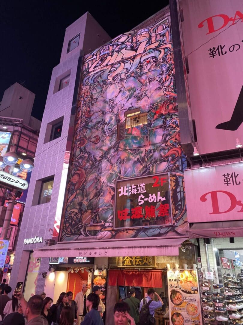 Vibrant urban street scene illuminated by colorful neon signs at night.