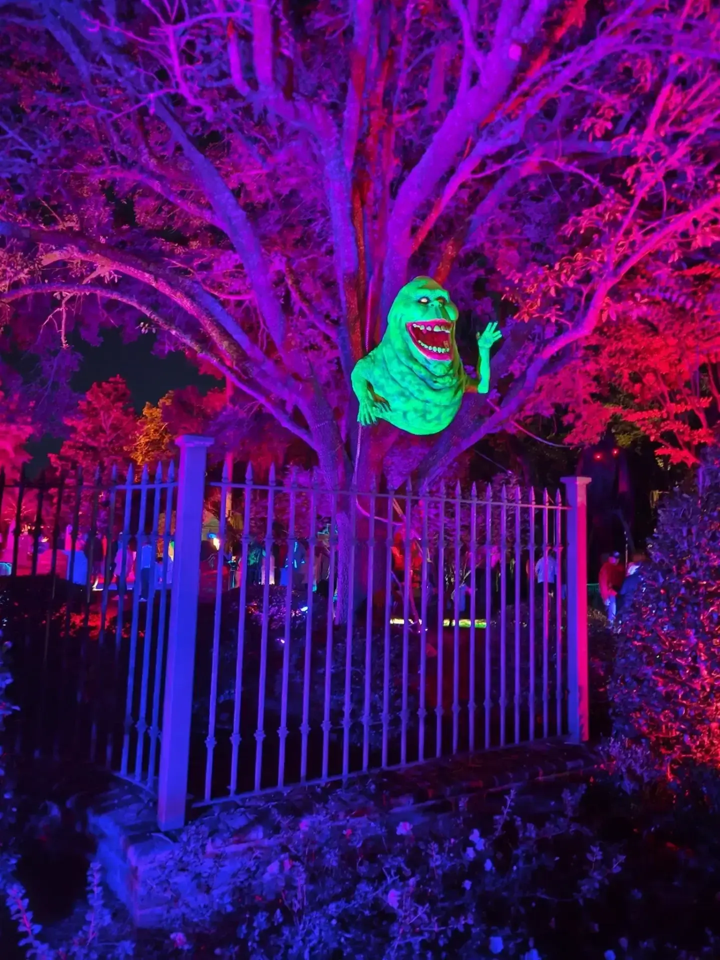 Glowing green figure on tree at night.