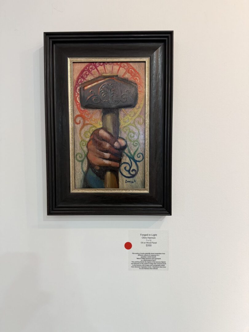 Framed painting of hand holding hammer.