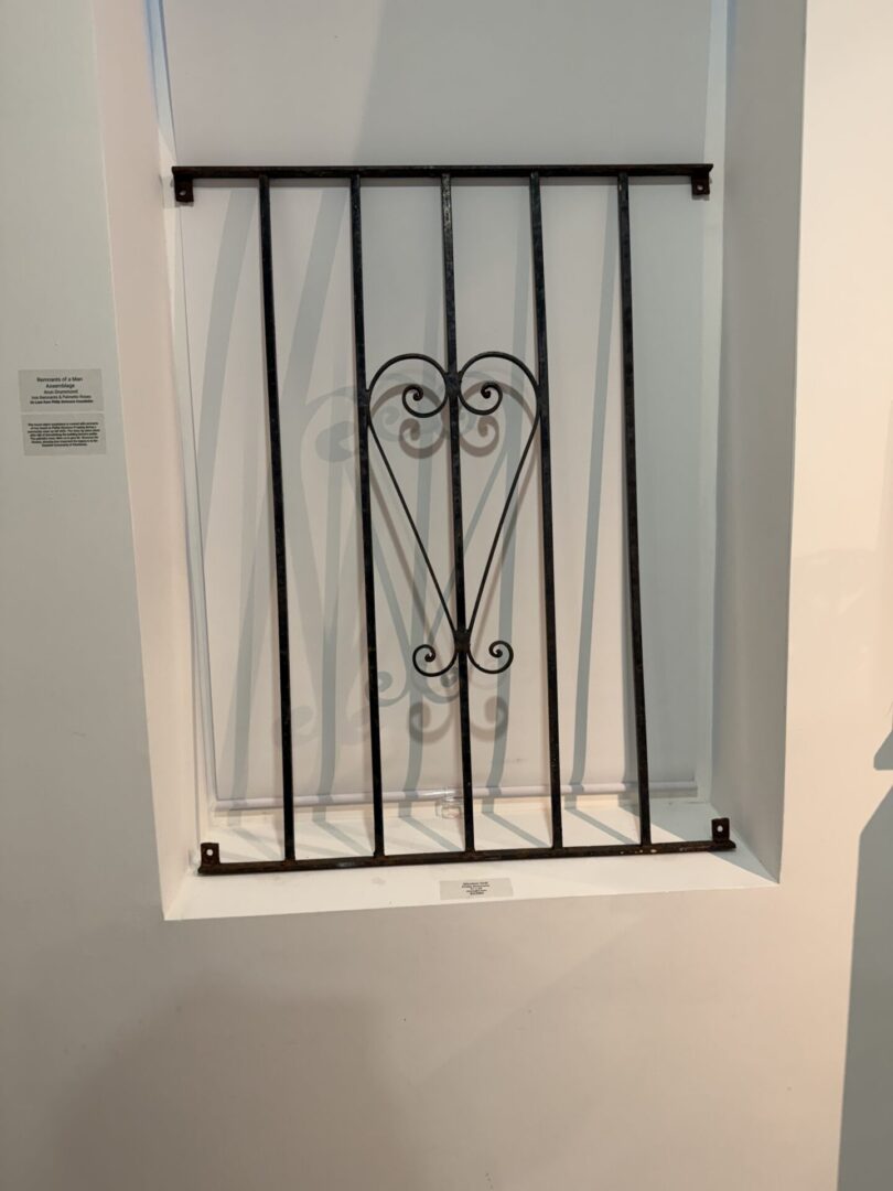 Decorative metal grate on white wall.