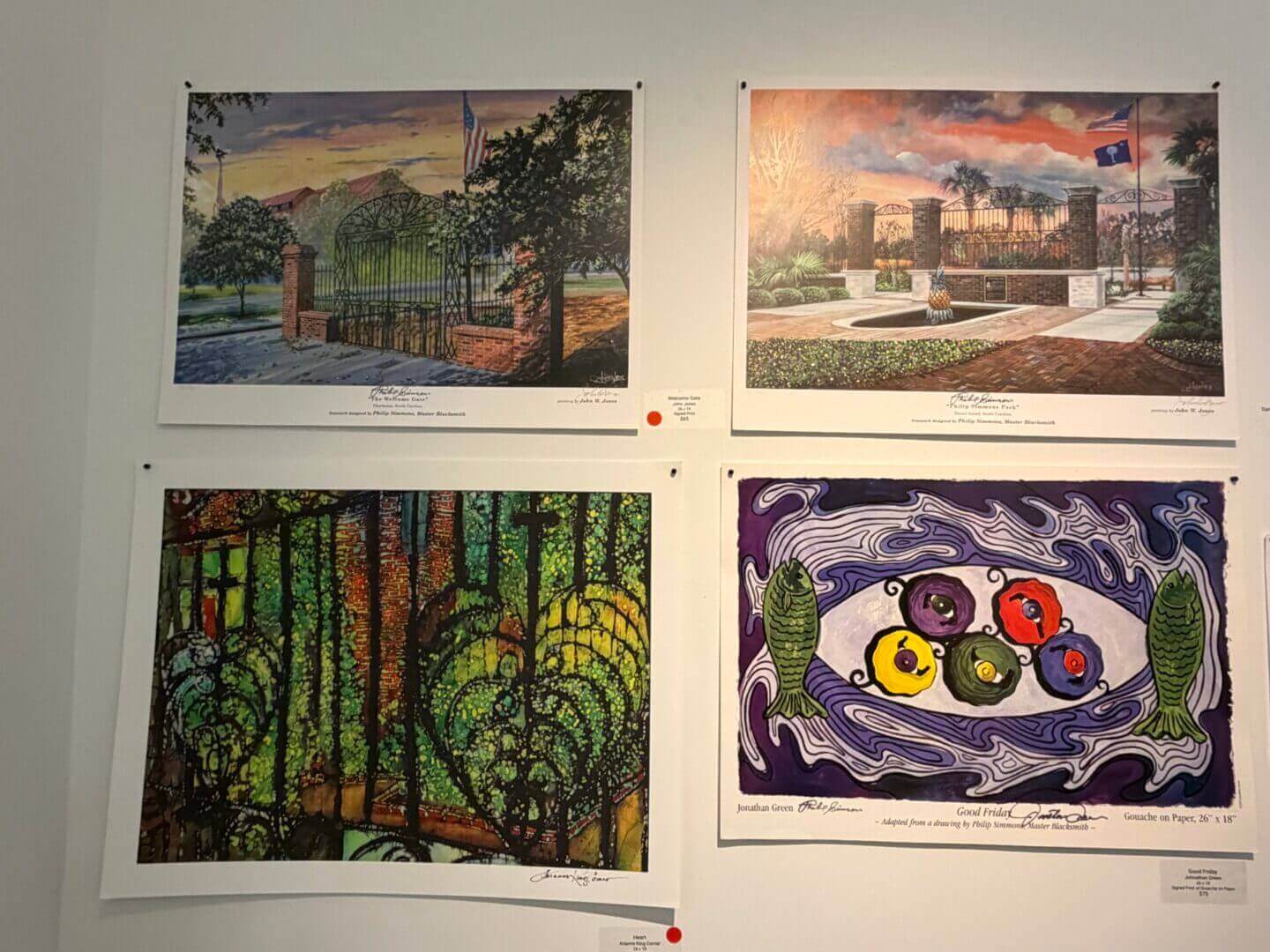 Four colorful paintings displayed on a wall.