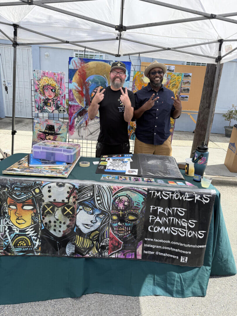 Artists at outdoor art booth display.