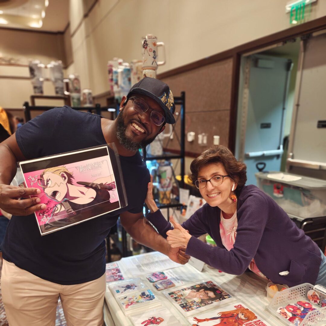 Two people smiling at a convention table.