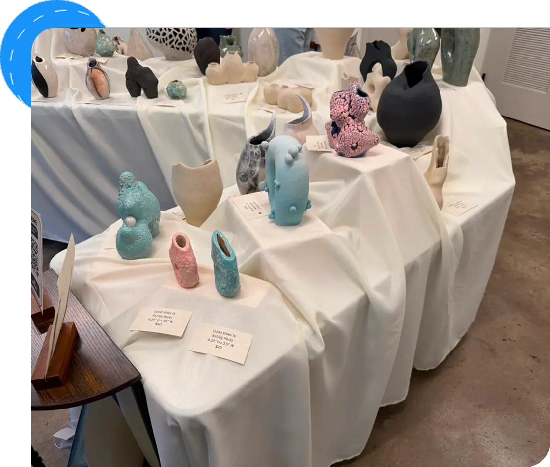 Ceramic sculptures displayed on draped tables.