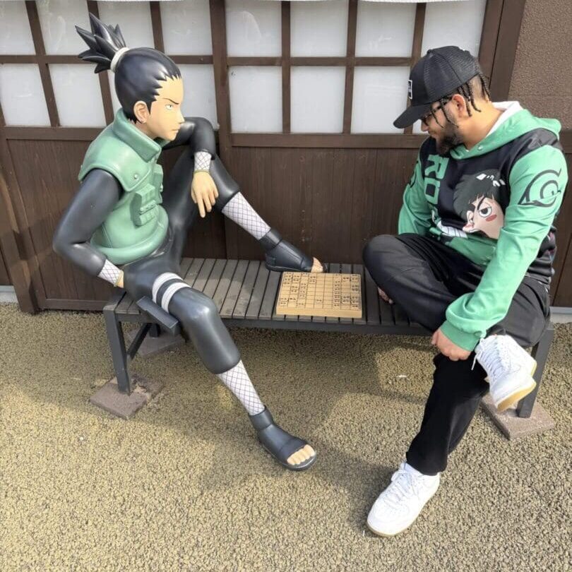 Two action figures in green vests posed on a carpet near a window.